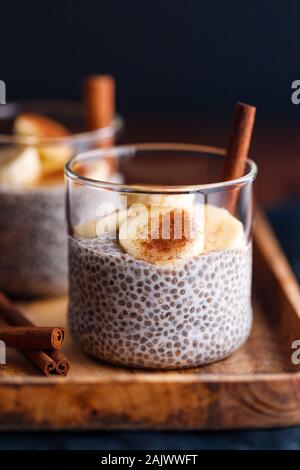 Chia Pudding mit Kokosmilch und Banane in Gläser auf einen Tisch. Vegetarische gesunde Dessert. Stockfoto