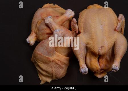 Broiler chicken und sein Fleisch auf schwarzem Hintergrund Stockfoto