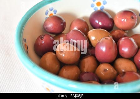 Typisch italienisch und Apulischen salzig und briney Oliven mit einem aromatischen Kraut Sole von Rosmarin, Lorbeer und Thymian geheilt, traditionelle Snack, Vorspeise Stockfoto