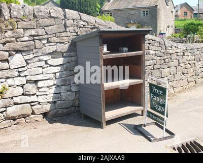 Ohne Personal Ehrlichkeit Stall oder Ehrlichkeit, indem ein trockenmauern Wand in einem Dorf in Derbyshire Verkauf von Eiern aus Freilandhaltung Stockfoto