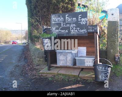 Ohne Personal oder Ehrlichkeit Ehrlichkeit stall Box am Straßenrand in Derbyshire Verkauf von Eiern aus Freilandhaltung und Gemüse aus eigenem Anbau mit einem cash Zinn Zahlung zu verlassen Stockfoto