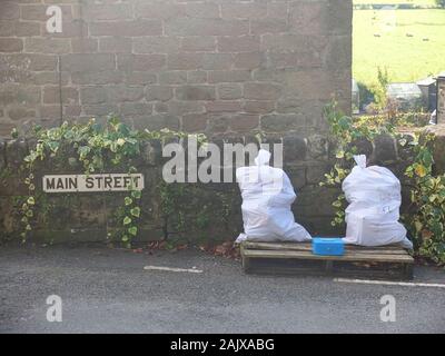 Ohne Personal oder Ehrlichkeit Ehrlichkeit stall Box auf einem Derbyshire Dorf Hauptstraße Verkauf von Brennholz für Holzofen mit Bargeld Zinn Zahlung zu verlassen Stockfoto