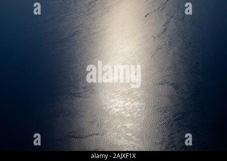 Sonnenlicht funkeln und die reflektierenden Meer Wasser. Funkelt auf dem Wasser. Sun reflektieren auf der Meeresoberfläche, Blick aus dem Flugzeug, dem Konzept der Reisen. Stockfoto