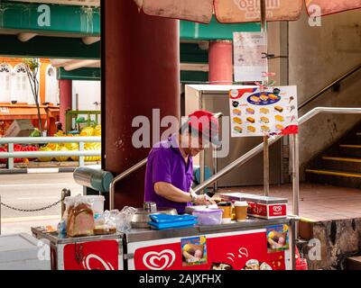 CHINATOWN, Singapur - 26 Dez 2019 - Eine ältere Menschen im mittleren Alter asiatischer Chinesischer Mann verkauft Eis Wafer/Eis Sandwiches aus einer retro Schubkarre. Thi Stockfoto