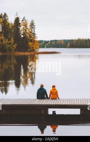 Paar in Finnland Familie lifestyle Liebe Beziehung Mann und Frau Freunde sitzen auf Pier im freien See und Wald landschaft Herbst reisen Stockfoto