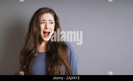 Junge Frau schreien oder schreien mit ihren Mund weit geöffnet Stockfoto