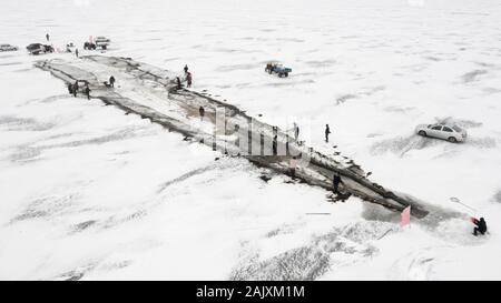 Chinesische Arbeiter ziehen einen riesigen fischernetz Eine gute Ernte auf dem zugefrorenen See in Wolong Kangping County, Shenyang City zu erwarten, im Nordosten Chinas Liaon Stockfoto