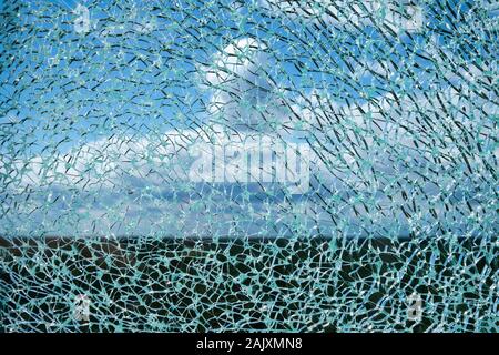 Risse Verbundglas Oberfläche gegen den blauen Himmel mit weißen Wolken unscharf im Hintergrund Stockfoto