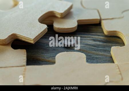 Close-up auf Unlackierten sperrholz Rätsel mit einem Stück herausgenommen, Holz- Oberfläche unter, Problemlösung und Teamarbeit Konzept Stockfoto