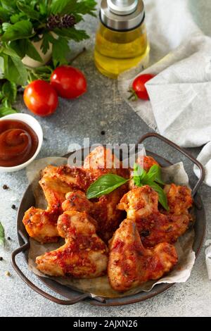 Leckeren Snack. Gebackene Chicken Wings mit Senf Tomatensoße auf einer konkreten Tabelle. Stockfoto