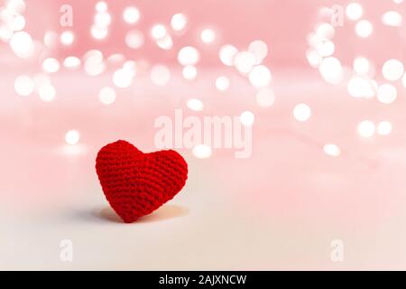 Schönen roten Herzen auf einem rosa Hintergrund mit Beleuchtung. Valentines Tag Symbol, Liebe, Romantik, dating Konzept mit Platz kopieren. Foto Valentinstag Stockfoto