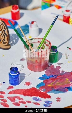 Artist: Pinsel in kann mit Wasser, helle Farben und Palette auf Tablet Stockfoto