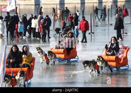 Die Menschen genießen Schlitteln auf dem gefrorenen Kunming See im Sommerpalast im Winter in Peking, China, am 4. Januar, 2020. Stockfoto