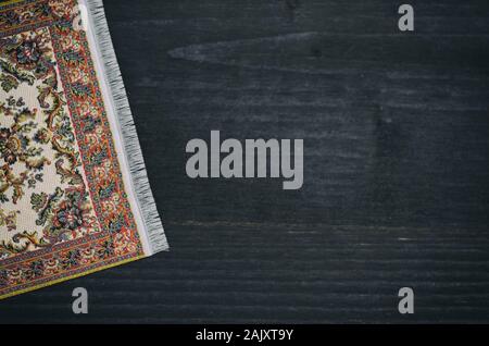 Oriental persischer Teppich auf schwarzem Holz- Hintergrund, die Dekoration. Stockfoto