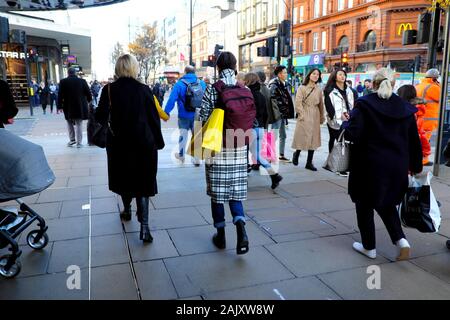 Ansicht der Rückseite des Menschen Frau mit Einkaufskorb außerhalb der Läden in der Oxford Street in West London England UK KATHY DEWITT Stockfoto