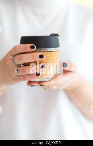 Frau Hände halten Sie wiederverwendbare Glas Kaffee Tasse. Nachhaltiges Leben. Umweltfreundliche, null Abfall Konzept. Stockfoto