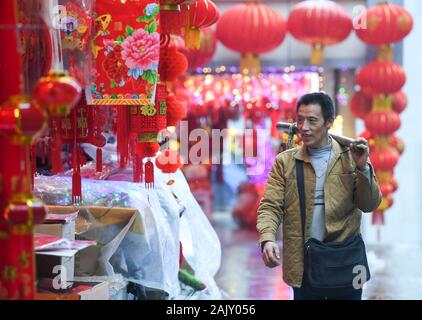 (200106) - chongqing, Januar 6, 2020 (Xinhua) - Lief Guanghui sieht für Kunden in der Nähe von Chaotianmen im Südwesten Chinas Chongqing Gemeinde, Jan. 5, 2020. Lief Guanghui, 50, hat sein Leben als 'Bang Bang', buchstäblich 'Tick', in Chongqing seit zehn Jahren erwarb. In einer bergigen Stadt Chongqing mit einer Fülle von hügeligen Straßen und Wege, stick Männer haben unterstützt Menschen, die von Gepäck und schwere Sachen. Schleppen waren auf Bambusstangen auf ihren Schultern ausgeglichen, der Stick Männer verdienten Brot im Schweiße Ihrer Augenbrauen. Ran wurde einer von ihnen im Jahr 2009 als er verließ seine Heimatstadt Dia Stockfoto