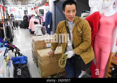 (200106) - chongqing, Januar 6, 2020 (Xinhua) - Lief Guanghui bewegt Waren, die in einem Einkaufszentrum bei Chaotianmen im Südwesten Chinas Chongqing Gemeinde, Jan. 5, 2020. Lief Guanghui, 50, hat sein Leben als 'Bang Bang', buchstäblich 'Tick', in Chongqing seit zehn Jahren erwarb. In einer bergigen Stadt Chongqing mit einer Fülle von hügeligen Straßen und Wege, stick Männer haben unterstützt Menschen, die von Gepäck und schwere Sachen. Schleppen waren auf Bambusstangen auf ihren Schultern ausgeglichen, der Stick Männer verdienten Brot im Schweiße Ihrer Augenbrauen. Ran wurde einer von ihnen im Jahr 2009, wenn er verließ sein Haus Stockfoto