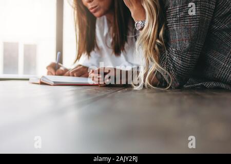 Junge erfolgreiche Frauen Kollegen gemeinsame Projekt, Coaching oder Mentoring am Tisch besprechen Stockfoto