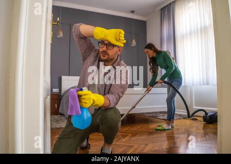 Junges Paar ist die Reinigung Ihrer Wohnung. Man ist müde. Stockfoto