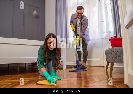 Junge glückliches Paar ist die Reinigung Ihrer Wohnung. Stockfoto