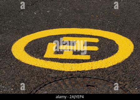 Südafrika. Dezember 2019. Eine frisch gestrichene Hydrant gelbes Schild neben einem Kanaldeckel. Stockfoto