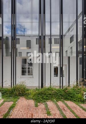 Verglasung und Reflexion im Innenhof. Desmond & Leah Tutu Legacy Foundation, Kapstadt, Südafrika. Architekt: Makeka Design Lab, 2019. Stockfoto