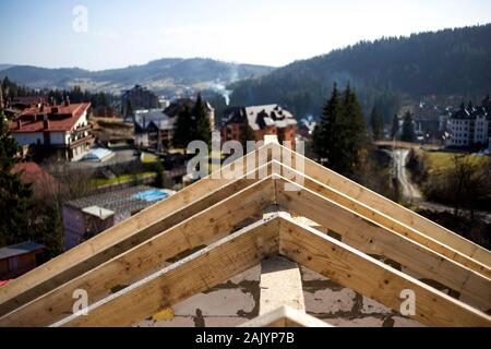 Close-up Detail der Dachrahmen aus grobem Holz Bauholz Balken auf dem Hintergrund von Misty Mountain Landschaft im ökologischen Bereich. Gebäude, Dach, constructi Stockfoto