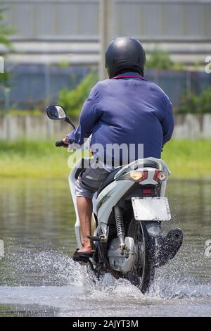 Splash von einem Motorrad wie geht es durch Hochwasser Stockfoto