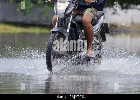 Splash von einem Motorrad wie geht es durch Hochwasser Stockfoto