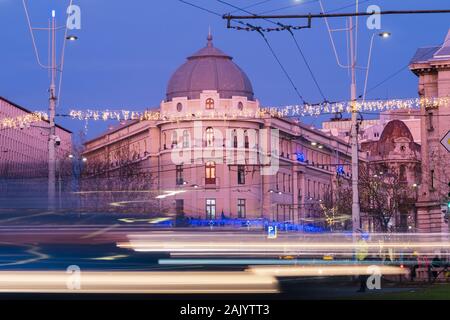 Bukarest, Rumänien - Dec 16, 2019: Rush Hour am Universitätsplatz, Bukarest, in der Innenstadt von Bukarest in der Dämmerung; und der Bukarester Nationaltheater (TNB) Stockfoto