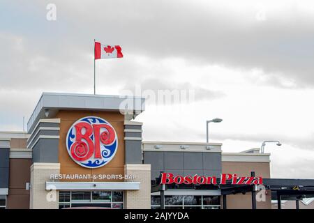 Calgary, Alberta. Kanada Jan 4 2020. Ein Boston Pizza restaurant Zeichen mit einer kanadischen Flagge. Boston Pizza International fügt fünf neue Restaurants und Stockfoto