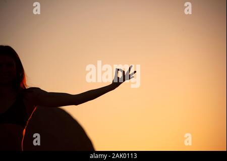 Yoga Frau in Silhouette abgeschnitten. Wüste yogini in der heiligen Natur Meditation mit der Hand in der heiligen Mudra. Stockfoto