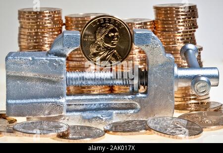 Stapel von Dollar Goldmünzen mit der Native American sacagawea Bild mit einer Münze in winzigen Silber Vice Stockfoto