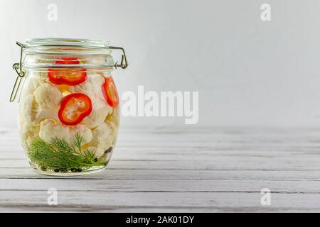 Glas Glas von fermentierten Blumenkohl. Gemüse auf einem hellen Hintergrund. Gärung ist eine Quelle von Probiotika. Kopieren Sie Platz Stockfoto
