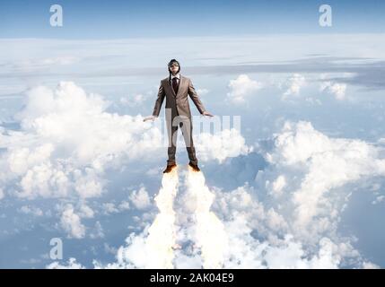 Geschäftsmann in Anzug und Aviator hat fliegen im Himmel Stockfoto