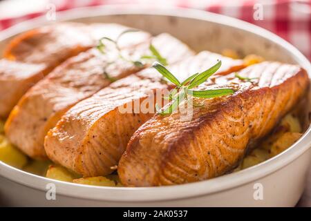 Gebackene Lachsfilets mit Kartoffeln und Kräuter in einer Auflaufform Stockfoto