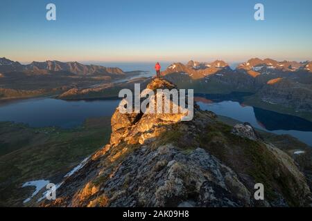 Männliche Wanderer mit Blick auf Berge von Selfjord vom Gipfel des Kitind, Moskenesøy, Lofoten, Norwegen Stockfoto