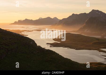 Dunstige sommer himmel in der Mitternachtssonne über Berge von Moskenesøy und Flakstadøy, Lofoten, Norwegen Stockfoto