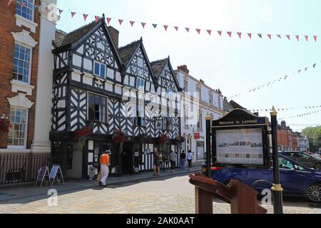 Eine Informationstafel vor einem 16. Jahrhundert schwarze und weiße Holz gerahmt Tudor Gebäude in der Bohrung Straße, Lichfield, Staffordshire, England, UK Stockfoto