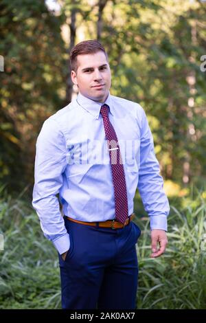 Selbstbewusster junger Mann in Hemd und Krawatte, der draußen steht. Stockfoto