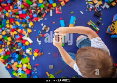 4 Jahre junge Gebäude einen Turm mit mit Verriegelung aus Kunststoff Ziegel Spiel. Selektiver Fokus Stockfoto