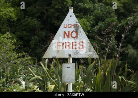 Parkplatz für drei Schwestern, Tongoporutu, Northern Taranaki, Neuseeland. Ein verwittertes weißes und rotes Licht kein Feuer Warnschild Wald, Busch, Brandsaison Stockfoto