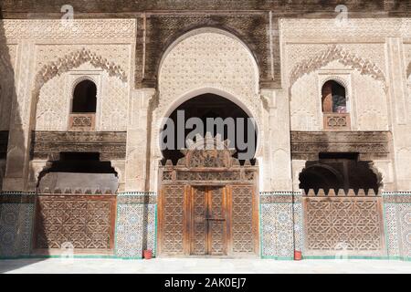 Eindrucksvolle Verzierungen (einschließlich Zellige und Muqarnas) auf dem Hof von Bou Inania Madrasa in Fes (Fez), Marokko