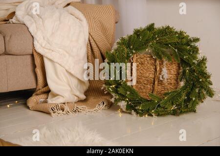 Zimmer mit einem weihnachtlichen Kranz aus einen Weihnachtsbaum mit einem Kranz in der Nähe der Sofa Stockfoto