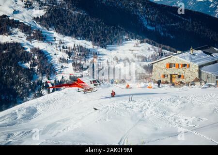 St Luc, Schweiz - 30. Dezember 2019: Swiss Mountain Rescue Helicopter, die nach der Ernte herauf verletzte Skifahrer in den Schweizer Alpen Ski Resort. Stockfoto