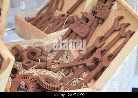 Schokolade Tools, Zahnräder, Messung der Bremssättel für den Verkauf in Holzbox mit Stroh auf der Straße Markt in Vilnius, Litauen Stockfoto