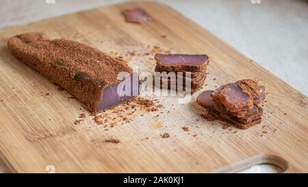 Schneiden Sie hausgemachtes Fleisch in Paprika auf Holzbrett Stockfoto