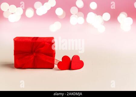 Zwei rote Herzen und roter Geschenkbox auf weißem Hintergrund mit Beleuchtung. Valentines Tag, Liebe, Romantik, Dating, Geschenk, Jahrestag Konzept mit Kopieren Stockfoto