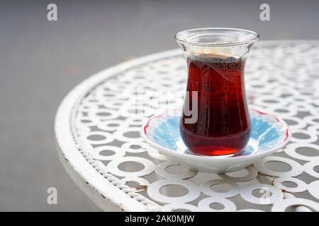 Serviert Kaffee in einem türkischen Kaffee Glas auf ein Metall cafe Tabelle auf der Straße. Stockfoto